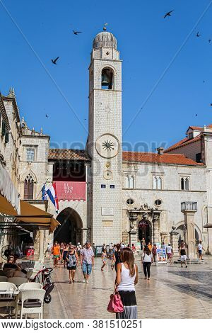Dubrovnik, Croatia - July 15th 2018: The Zvonik Clock Tower At Orlando's Column And The Church Of Sa