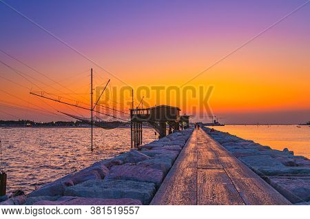 Traditional Fishing Station House With Fishnet In Water Of Adriatic Sea At Pier Diga Sottomarina, Sk