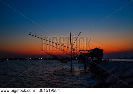 Traditional Fishing Station House With Fishnet In Water Of Adriatic Sea At Pier Diga Sottomarina, Sk