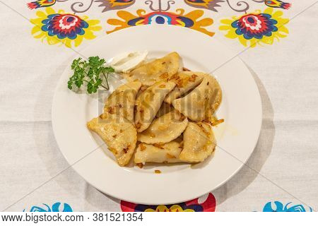 Pierogi Served On A Plate Ready For Eating With Lowicz Pattern Table Cloth