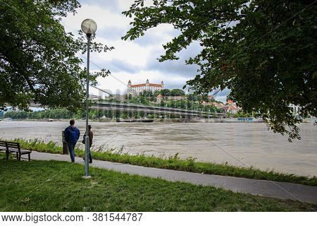 Bratislava, Slovakia - July 5th 2020: People Walking Along A Footpath By The River Danube In Bratisl