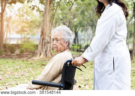Doctor Help And Care Asian Senior Or Elderly Old Lady Woman Patient Sitting On Wheelchair At Park In