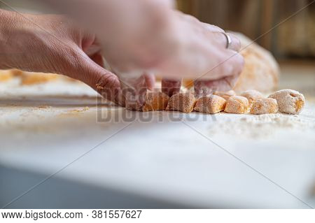 Low Angle View Of Female Hands Making Delicious Vegan Sweet Potato Gnocchi On Kitchen Counter.