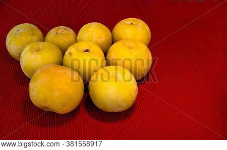 Large Yellow Plups On Red Cloth Napkin On The Table Closeup