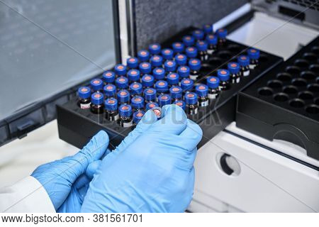 Chemist Putting Vial With A Sample Into Autosampler Of Hplc System. High Performance Liquid Chromato