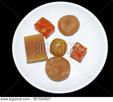 Indian Sweets Served In White Plate. Halwa, Badusha, Ghee Mysore Pak, Laddu In Decorative Plate,