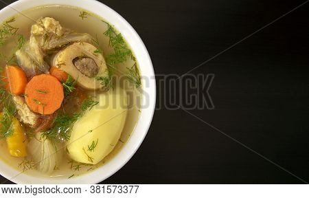 Shurpa Soup In A White Bowl On Dark Wooden Background With Copy Space. Top View. Famous Traditional 