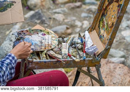 Dombay, Russia 26 July 2020: Close Up Of Young Woman Drawing Picture On Cardboard On Hike. Paintress