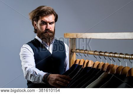 Man Suit, Tailor In His Workshop. Male Suits Hanging In A Row. Tailor, Tailoring. Stylish Mens Suit.