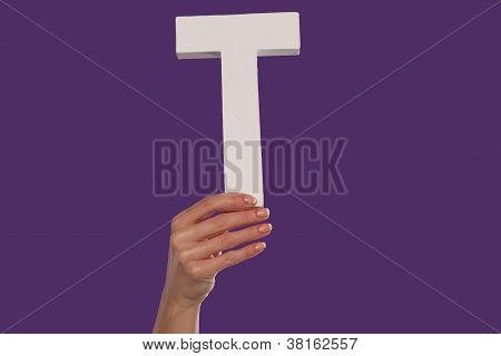 Femelle main tenant la lettre T du bas