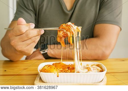 Man Eating Cheese Tokboki (korean Hot And Spicy Rice Cake) In A Canteen.