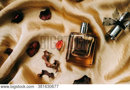 Perfume Bottle On Golden Satin Fabric With Dried Flower Petals, Close-up, Warm Light. . High Quality