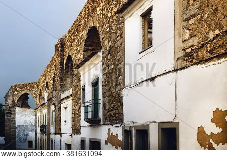Houses In Evora (alentejo, Portugal) Along The Ancient Agua Da Prata Aqueduct. Buildings Were Built 