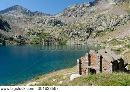 Mountain Lake With Ruined Military Barracks From World War 1