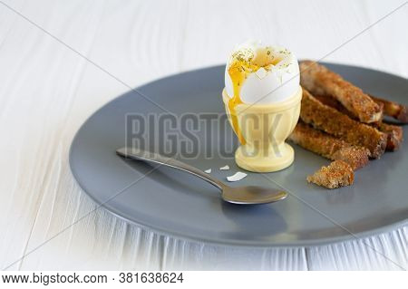 Soft Boiled Runny Egg In An Eggcup With Toasted Bread For Breakfast