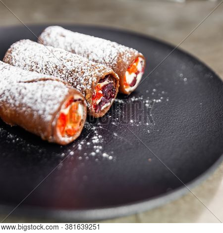 Traditional Italian Dessert Cannoli On Black Plate.
