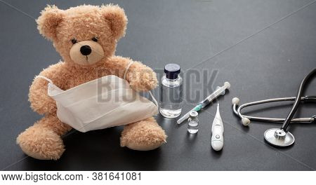Coronavirus Protection Concept. Teddy Bear And Protective Face Mask On Gray Background