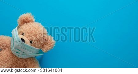Coronavirus And Pollution Protection Concept. Teddy Bear With Protective Face Mask On Blue Backgroun