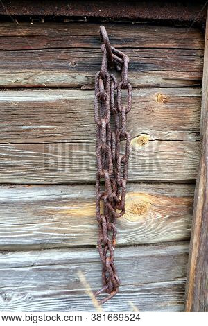 An Old Chain Hanging On A Wooden Wall