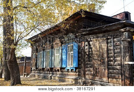Het houten huis met blinden van het venster op Irkoetsk street