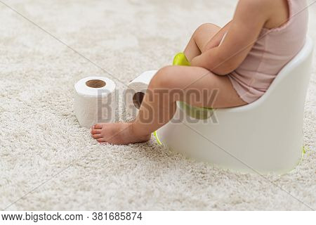 Child Girl On The Potty At Home.