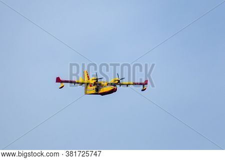 Close Up Of A Fire Fighting Water Bomber Airplane Flying Over Head, Dropping Water On Wildfires In C