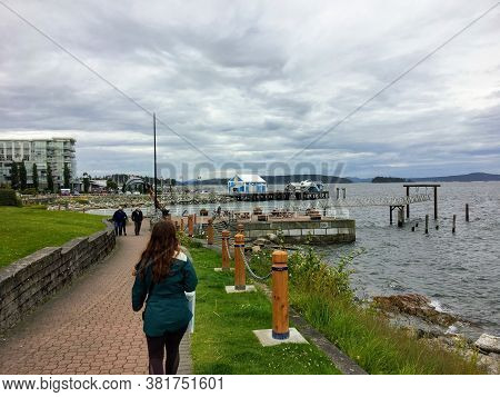 Sidney, British Columbia, Canada - July 1st, 2020: People Walking Along The Boardwalk Overlooking Th