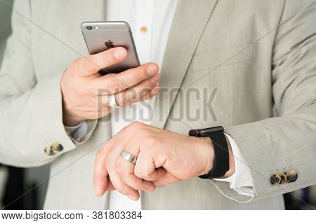 Ostfildern, Germany - May 14, 2015: A Businessman Is Checking His Apple Watch While Using His Iphone
