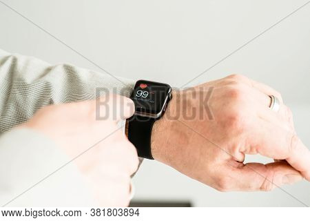Ostfildern, Germany - May 14, 2015: A Businessman Is Checking His Pulse Using His Black Apple Watch 