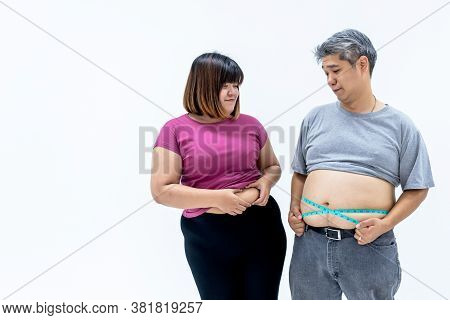 Portrait Images Of Asian Couple, Fat Man And Woman, Are Looking At Each Other's Belly Fat, On White 