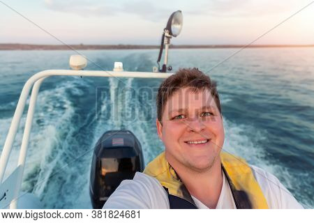 Young Adult Happy Caucasian Excited Man Portrait Enjoy Having Fun Driving Fast Motorboat On Pond Wat