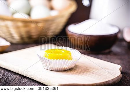 Egg Yolk Candy, Called Quindim In Brazil, And Portugal In Brisa-do-lis. Sweet Dessert On Rustic Wood
