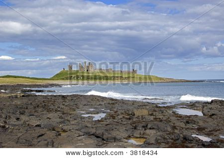 Dunstanburgh Castle pobřeží s vlnami