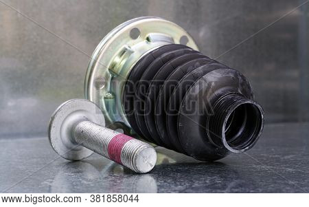 The New Protective Cover Of The Drive Shaft Of A Modern Car And The Hub Bolt On A Steel Background. 