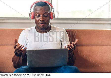 Young Black African Man Relaxing Using Laptop Computer Working And Video Conference Meeting At Home.