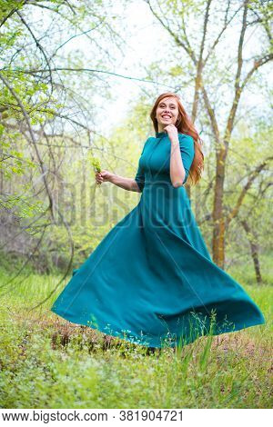Beautiful Bootless Woman Dance In Forest. Barefoot Girl In Elegant Blue Dress Posing In Forest On Gr