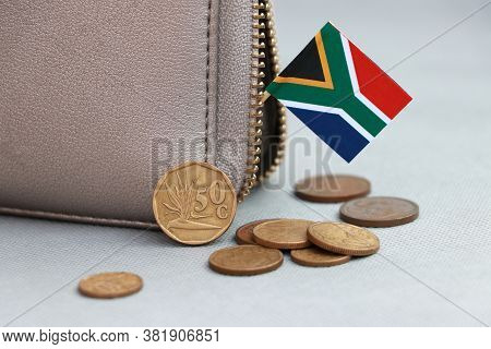 Heap Of South African Rand Coin Money And Mini South African Flag Stick On The Leather Wallet On Gre