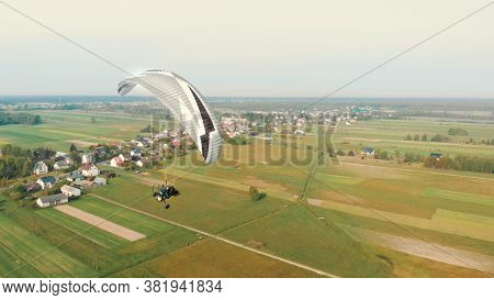 Paraglider Tandem Paramotor Flying In The Air - Countryside Of Poland. High Quality Photo