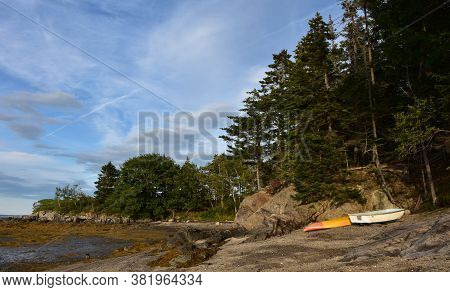 Abandoned Row  Boat And Kayak On A Deserted Beach.