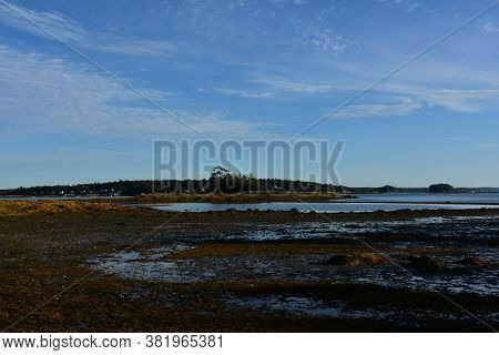 Low Tide Showing A Land Bridge To A Rocky Reef.