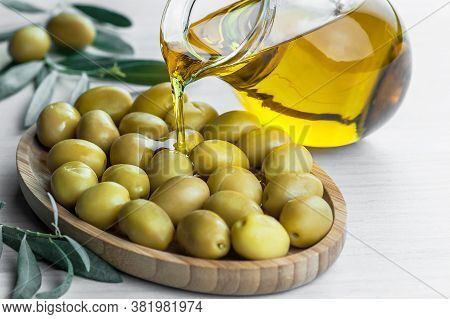 Glass Bottle Of Homemade Olive Oil And Olive Tree Branch, Raw Turkish Green Olive Seeds And Leaves O