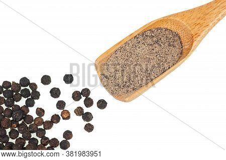 Close Up Heap Of Black Pepper In Wooden Spoon, Peppercorns And Milled Pepper Powder Isolated On Whit