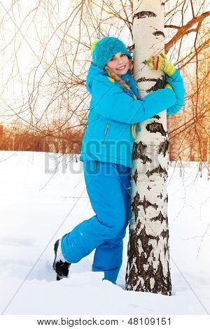 Glückliche Mädchen umarmen Baum