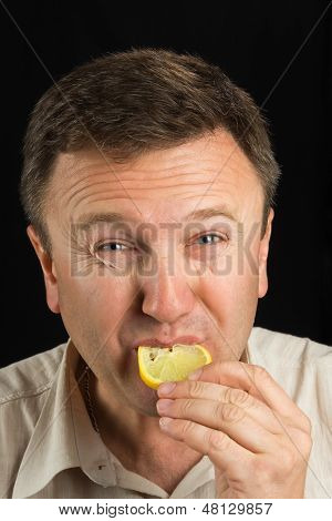 En mand spiser en citron