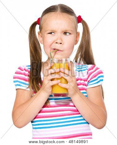 Liten flicka motvilligt dricka apelsinjuice med halm, isolerade över vita