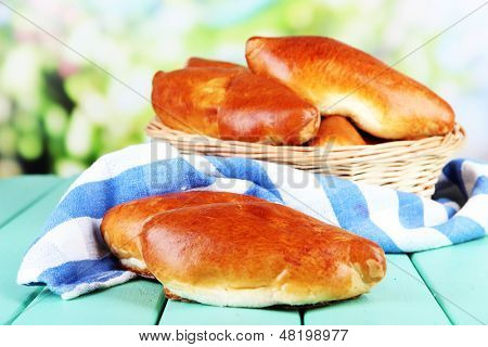 Empanadillas al horno frescos en cesta de mimbre, sobre fondo brillante
