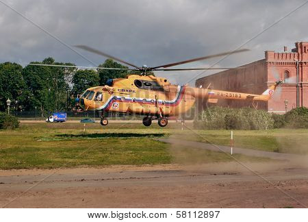 Orange Russian Mi-8 Helicopter Is Landing On Grass Lawn.