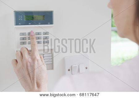 Woman Setting Control Panel On Home Security System
