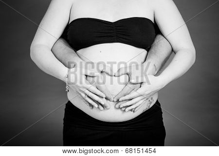 Mother and Father holding baby bump.