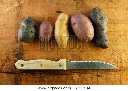 Variedade de alevinos de batatas na mesa de madeira